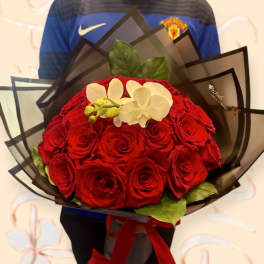 Bouquet of red roses with white orchids wrapped in dark paper