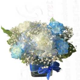Blue and white flower arrangement in a square glass vase with a blue ribbon