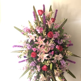 Large standing spray with pink lilies, red roses, and purple flowers