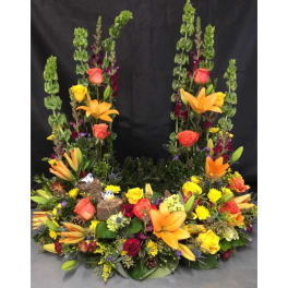 Large floral arrangement with lilies, roses, and tall green spikes