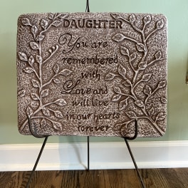 Decorative plaque on a metal stand with the words "Daughter, You are remembered with love and will live in our hearts forever"