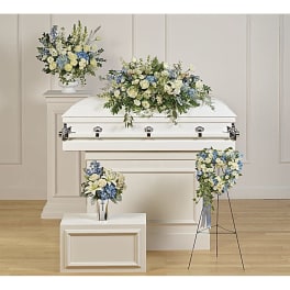 White casket with blue and cream floral sprays