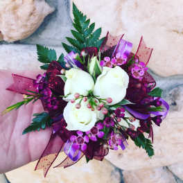 Small bouquet of white roses and purple flowers with ribbon