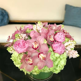 Pink and green floral arrangement in a glass bowl vase