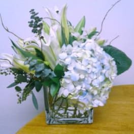 White floral arrangement in a square glass vase
