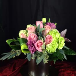 Pink roses and green hydrangeas arranged in a black vase