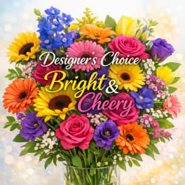 Bright mixed bouquet of roses, gerbera daisies, and other flowers in a glass vase