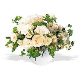 Cream roses arranged in a low clear glass vase