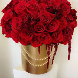 Large bouquet of red roses in a gold box with pearl strands