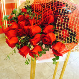 Bouquet of red roses wrapped in orange mesh