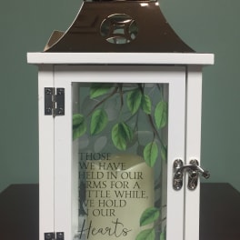 White memorial lantern with a candle and leaf design