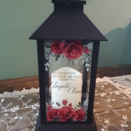 Black lantern with red roses and a memorial message inside
