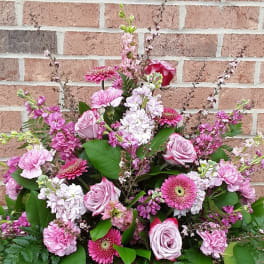 Large pink floral arrangement with roses, gerbera daisies, and carnations