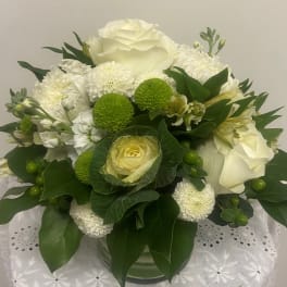 White and green floral arrangement in a glass vase