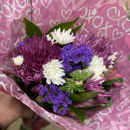 Bouquet of purple and white chrysanthemums wrapped in pink heart paper