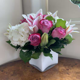 Pink roses and white lilies in a white square vase