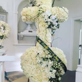 Large white floral standing spray with a black ribbon sash