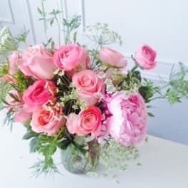 Pink roses and peonies in a clear glass vase