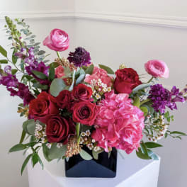 Bouquet of pink and red flowers in a black vase