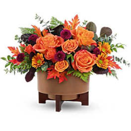 Orange roses and autumn flowers arranged in a low container