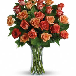 Bouquet of orange and red roses in a clear glass vase