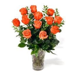 Arrangement of bright orange roses in a clear glass vase
