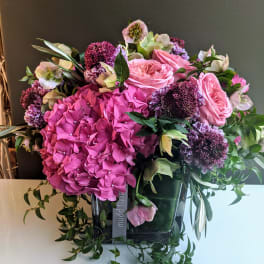 Pink and purple floral arrangement in a dark vase
