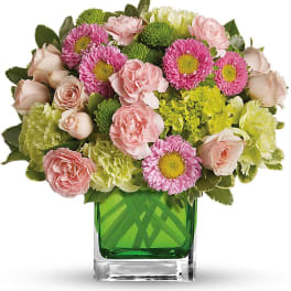 Pink and green mixed bouquet in a square glass vase