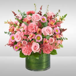 Pink mixed flower arrangement in a green vase