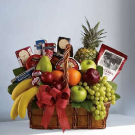 Fruit basket with bananas, grapes, apples, pineapple, and packaged snacks