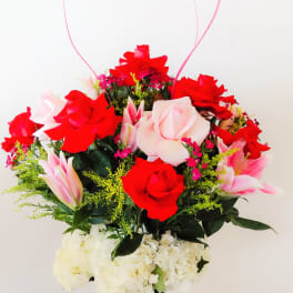 Bouquet of red and pink roses with lilies in a glass vase