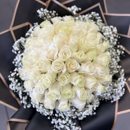Bouquet of white roses with baby's breath in black wrap