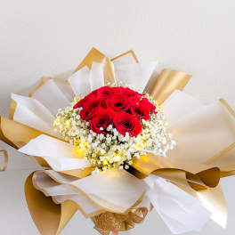 Bouquet of red roses wrapped in white and gold paper