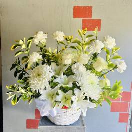 White lilies and chrysanthemums in a white basket