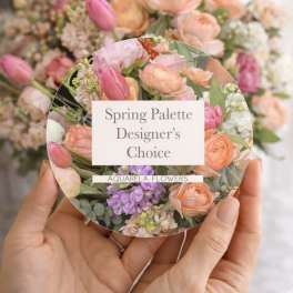 Hands holding a round floral card with pastel spring flowers