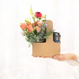 Mixed bouquet in a cardboard gift box with a travel cup