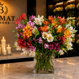 Large mixed bouquet of colorful alstroemeria in a clear glass vase