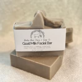 Stacked goat milk soap bars with a label on top
