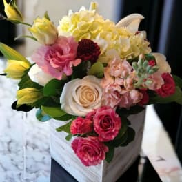 Mixed bouquet of roses, hydrangea, and lilies in a white box
