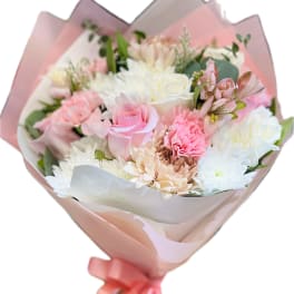 Bouquet of pink and white flowers wrapped in pastel paper