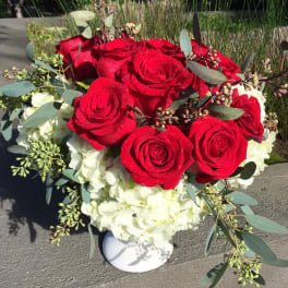 Red roses and white hydrangeas in a white vase