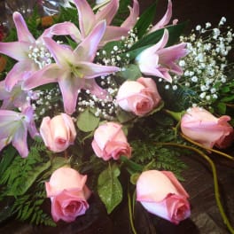 Pink lilies and roses arranged with baby's breath
