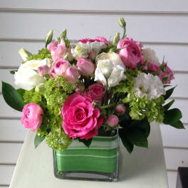 Pink and white bouquet in a square glass vase