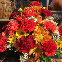 Basket arrangement of red, orange, and yellow flowers