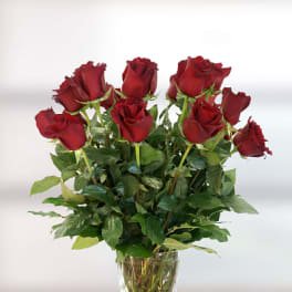 Red roses arranged in a clear glass vase