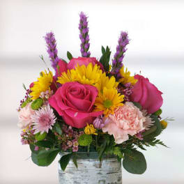 Pink roses and yellow daisies in a glass vase