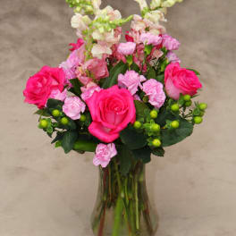 Pink roses and carnations in a clear glass vase