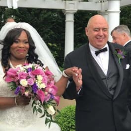 Bride holding a pink and white bouquet beside a groom in a tuxedo