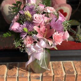 Pink mixed bouquet in a vase with a ribbon bow