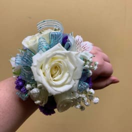 White rose wrist corsage with blue ribbon and purple accents